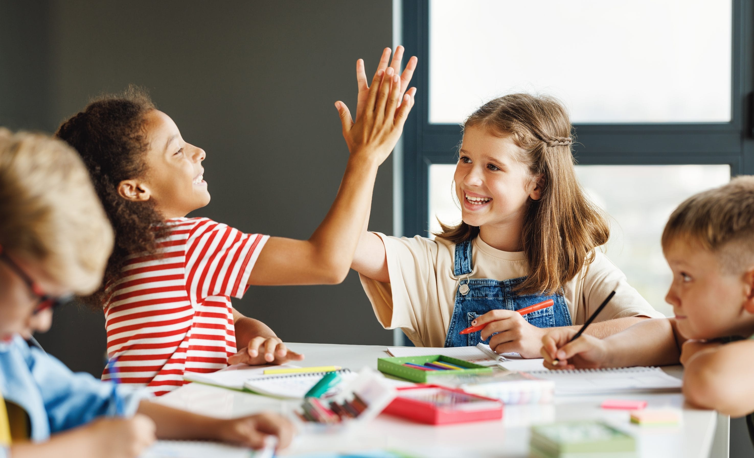 Children in a radon free classroom high-fiving
